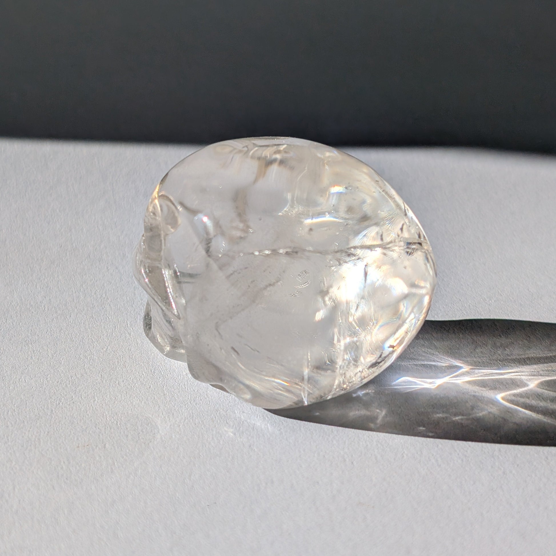 Kristallschädel "Dunhan" (268g) aus sehr klarem Bergkristall, der das Licht bricht.