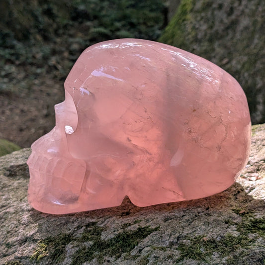 Kristallschädel "Elara" aus milchig-rosa Rosenquarz mit inneren Regenbogen-Einschlüssen.