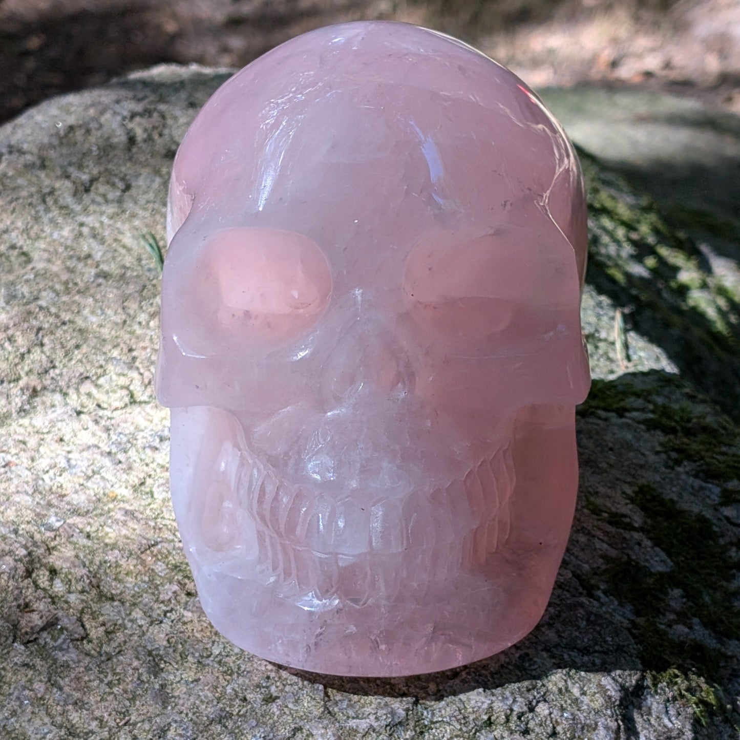 Kristallschädel "Elara" aus milchig-rosa Rosenquarz mit inneren Regenbogen-Einschlüssen.