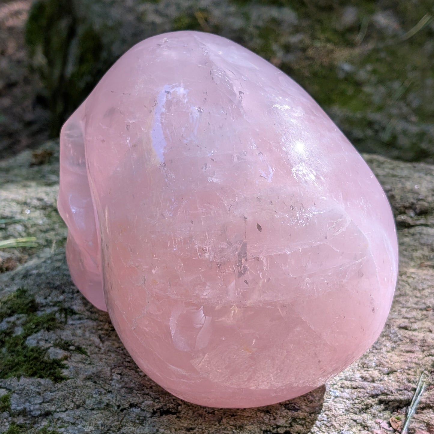 Kristallschädel "Elara" aus milchig-rosa Rosenquarz mit inneren Regenbogen-Einschlüssen.
