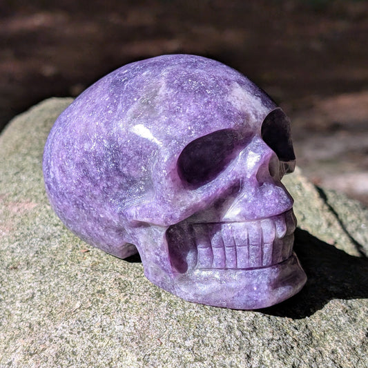 Kristallschädel "Friedenswächter" aus lila Lepidolith mit schimmernden Einschlüssen.