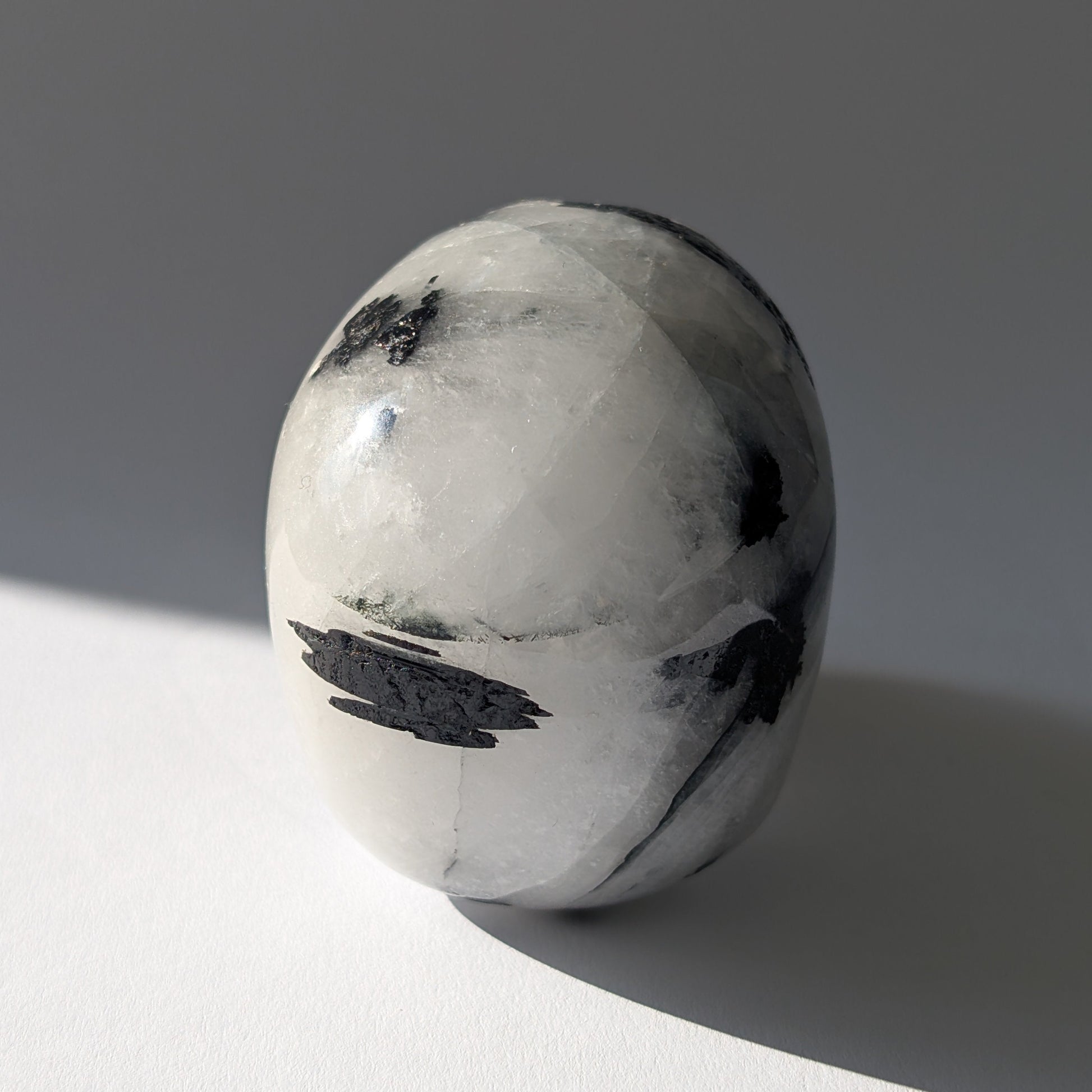 Kristallschädel "Hokan" (436g) aus klarem Quarz mit schwarzen Turmalin-Nadeln.