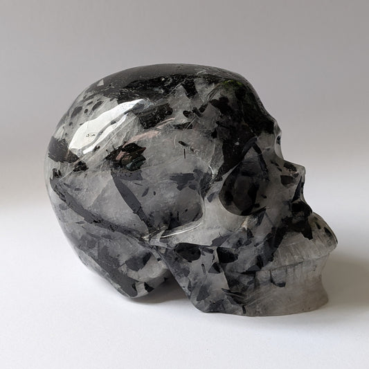 Kristallschädel "Kosmoswächter" aus klarem Quarz mit schwarzen Turmalin-Nadeln.