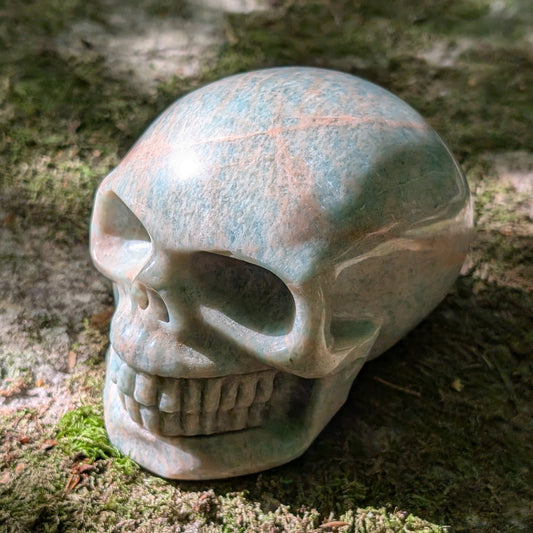 Kristallschädel "Ozeanfrieden" aus Amazonit mit blauer und grauer Maserung.