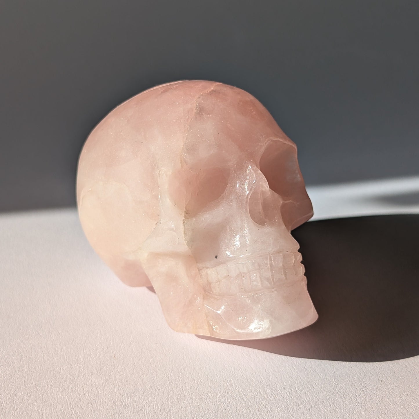 Kristallschädel "Sairun" (434g) aus zartrosa Rosenquarz im Seitenprofil.