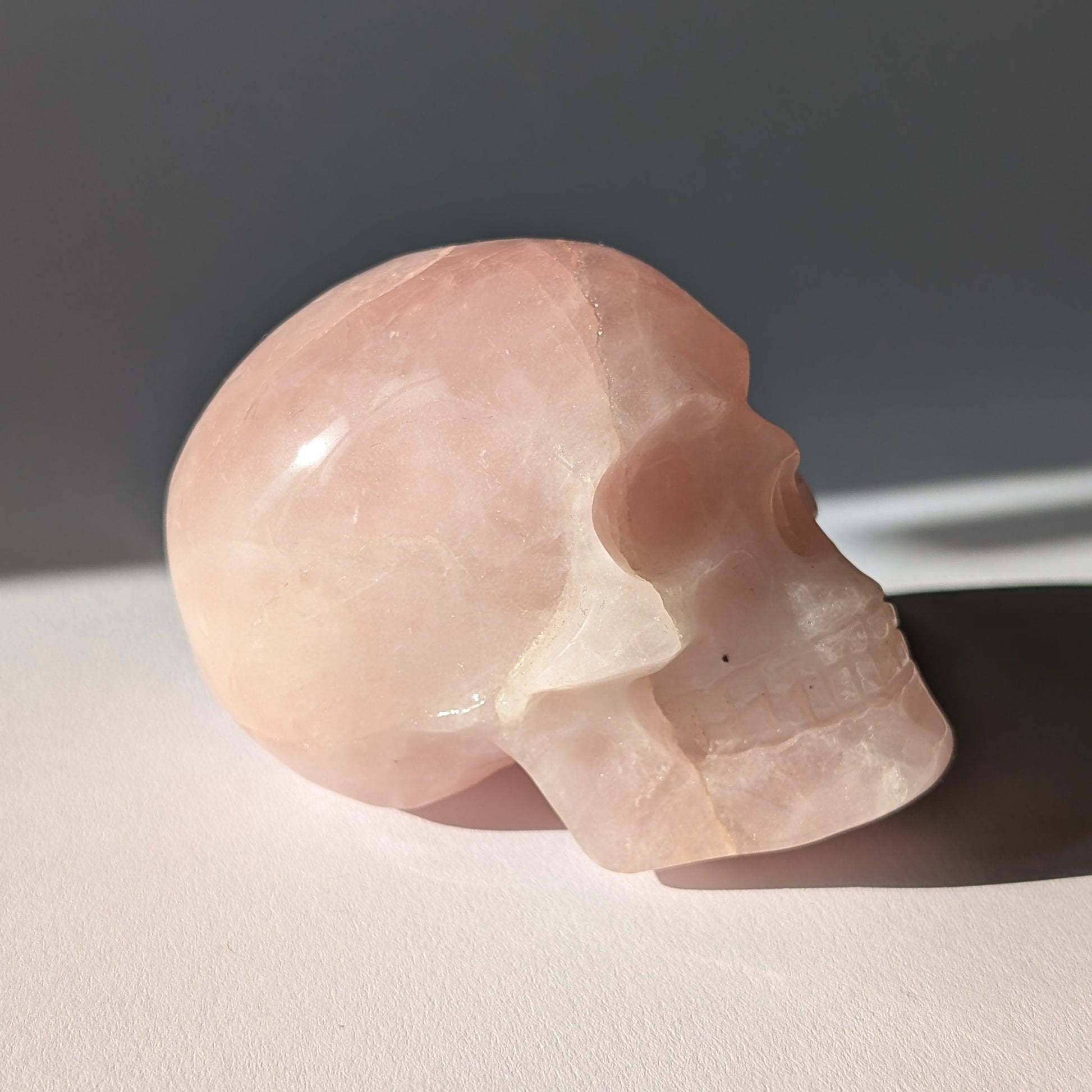 Kristallschädel "Sairun" (434g) aus zartrosa Rosenquarz im Seitenprofil.