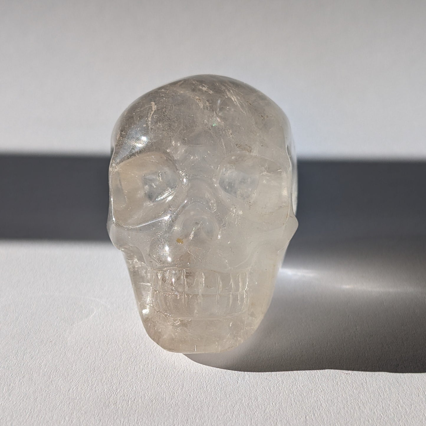 Kristallschädel "Sayir" (342g) aus klarem Bergkristall mit inneren Lichtreflexionen.