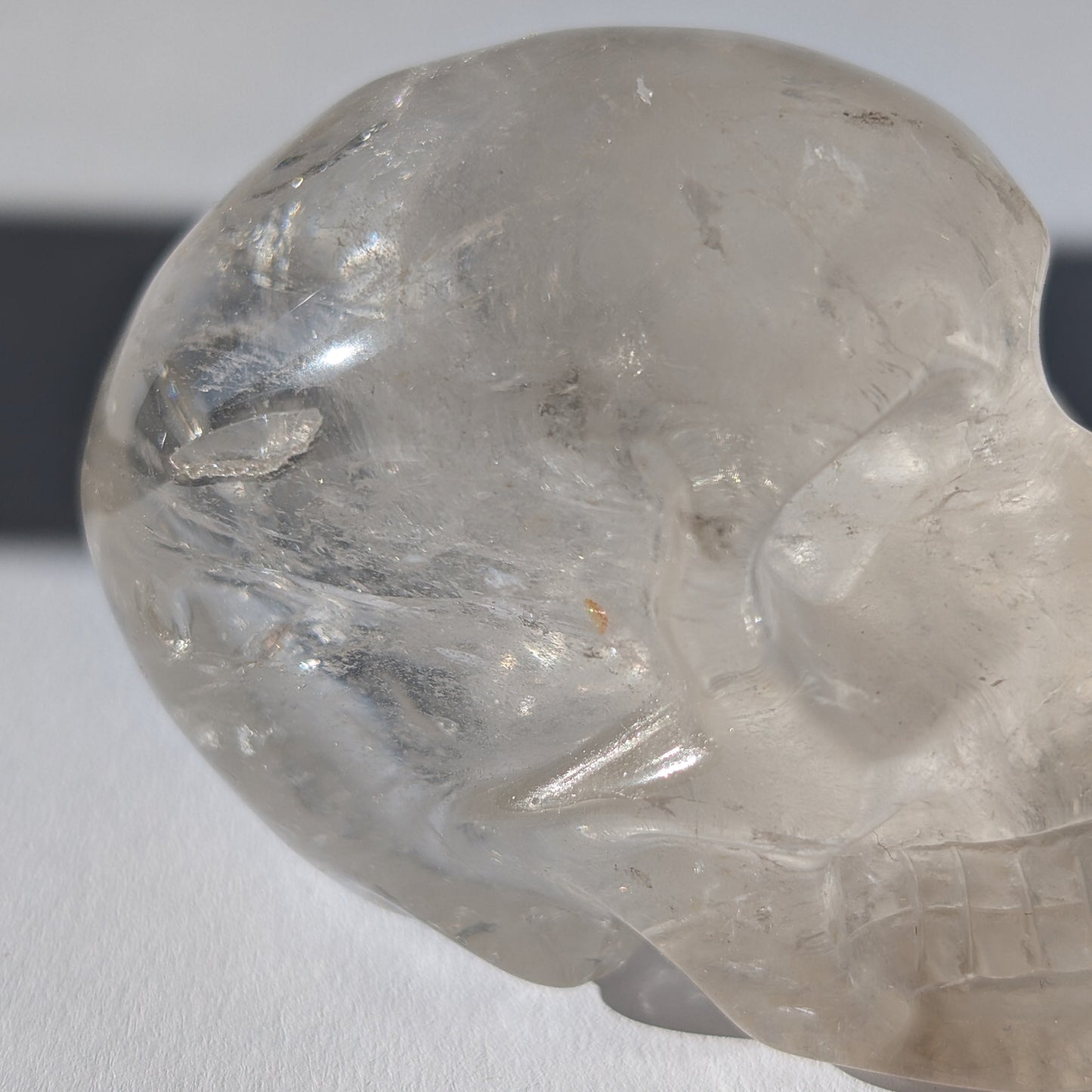 Kristallschädel "Sayir" (342g) aus klarem Bergkristall mit inneren Lichtreflexionen.