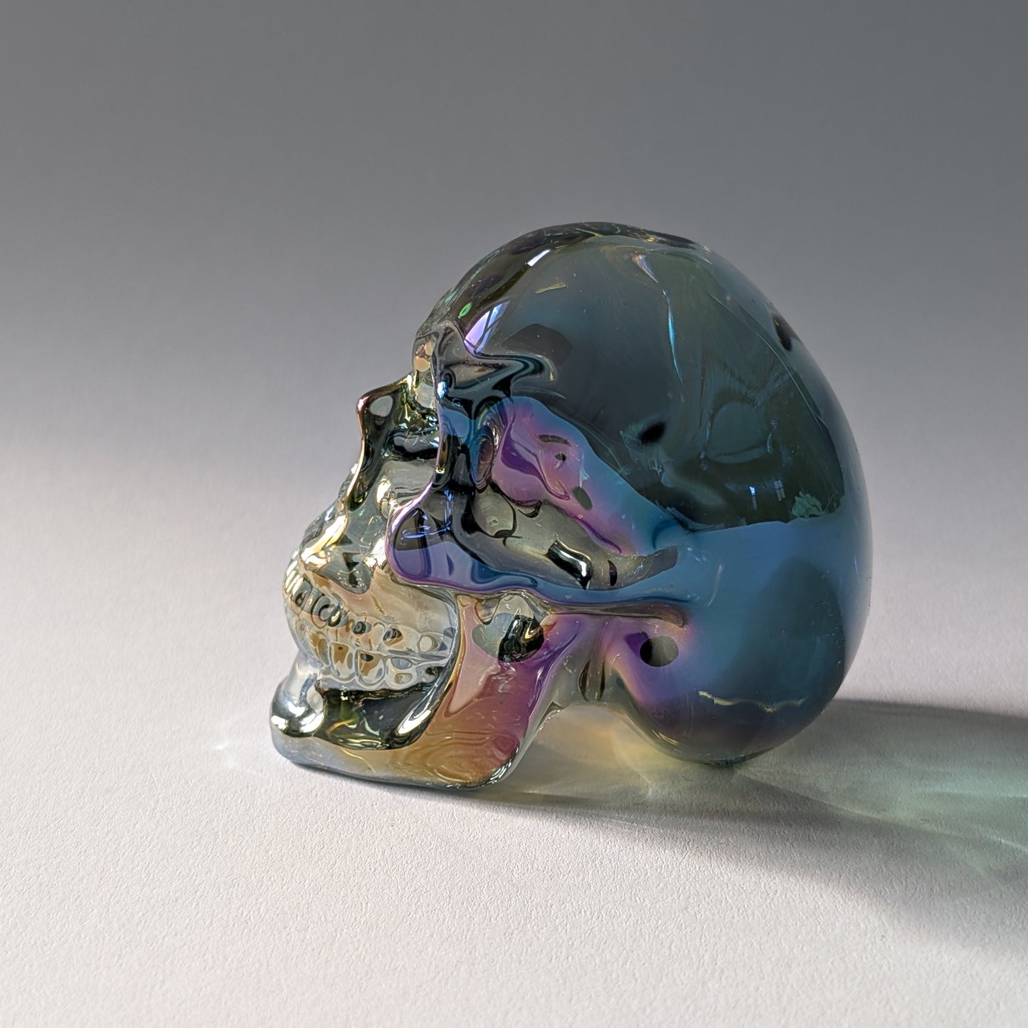 Kristallschädel "Trokan" (298g) aus Quarz mit schillernder Rainbow-Aurora Beschichtung.