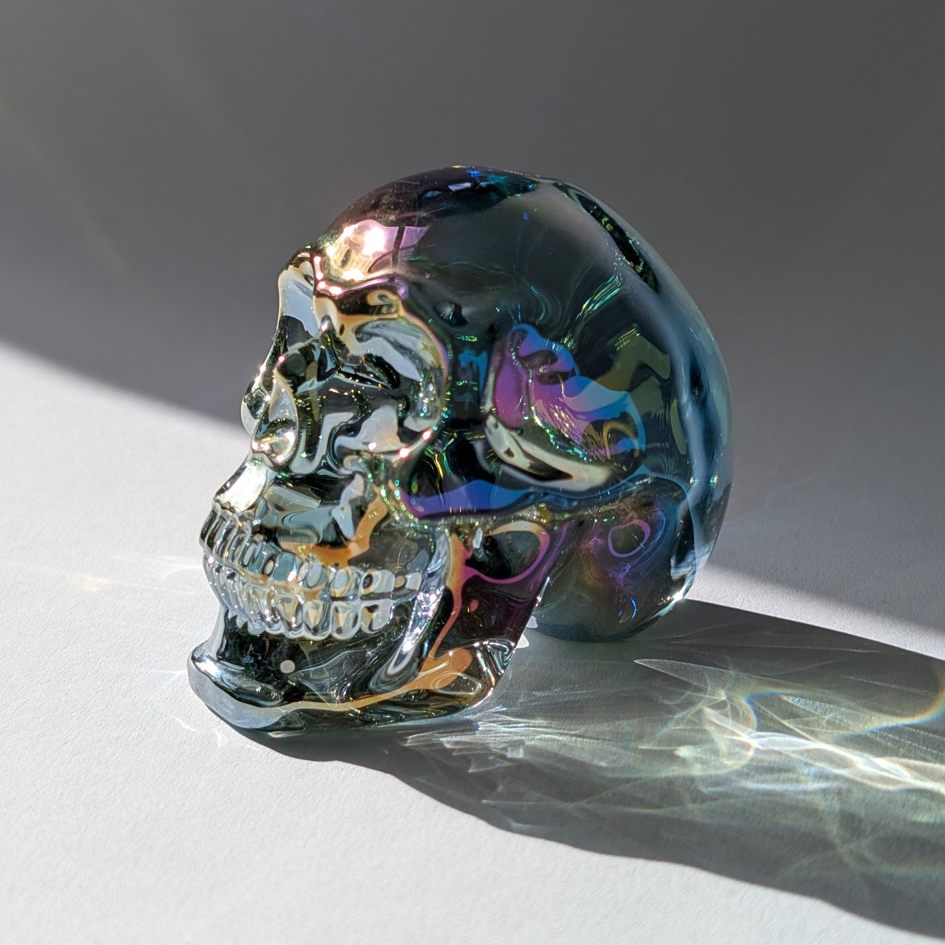 Kristallschädel "Trokan" (298g) aus Quarz mit schillernder Rainbow-Aurora Beschichtung.