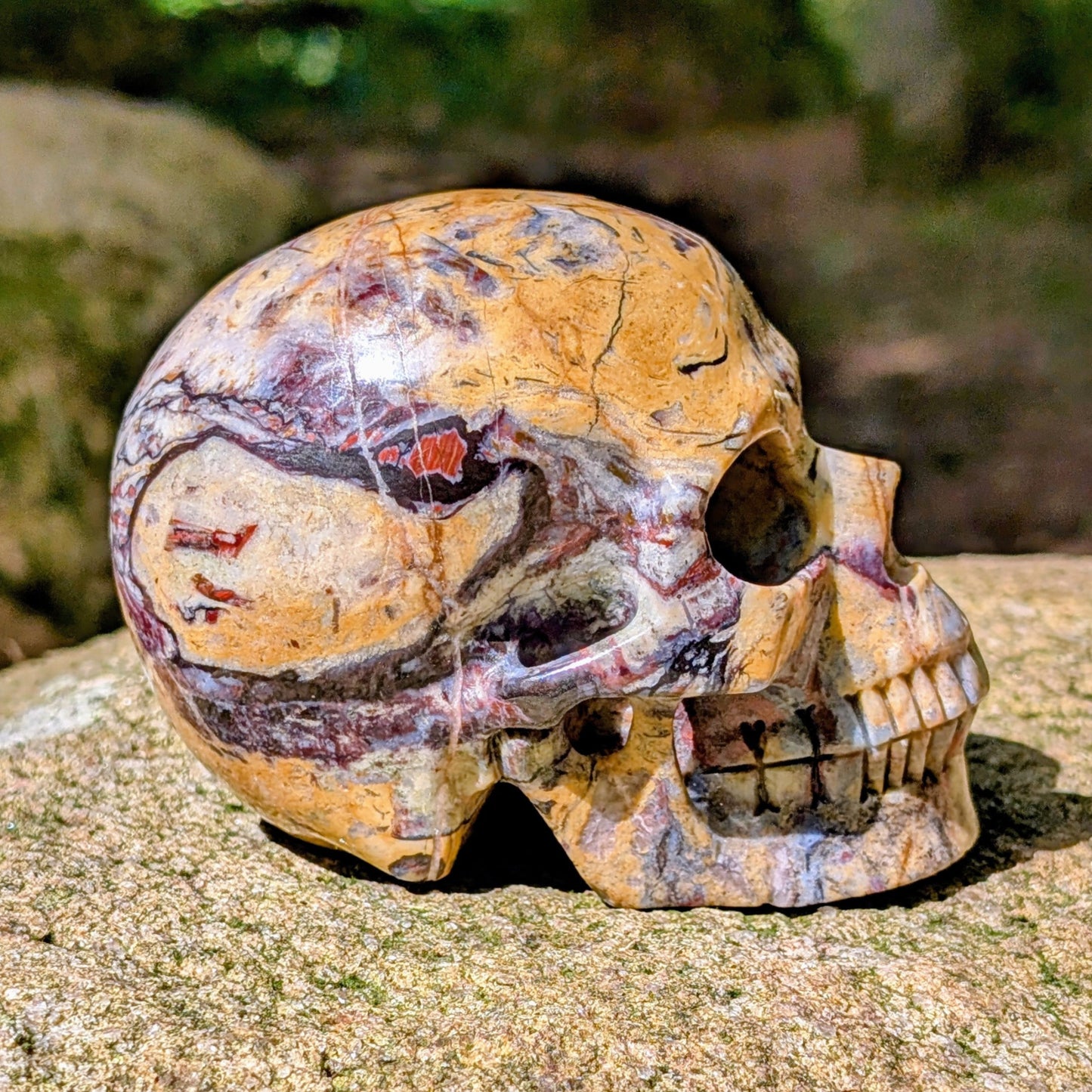 Kristallschädel "Wüstenwächter" aus Polychrom-Jaspis mit rötlicher und gelber Maserung.