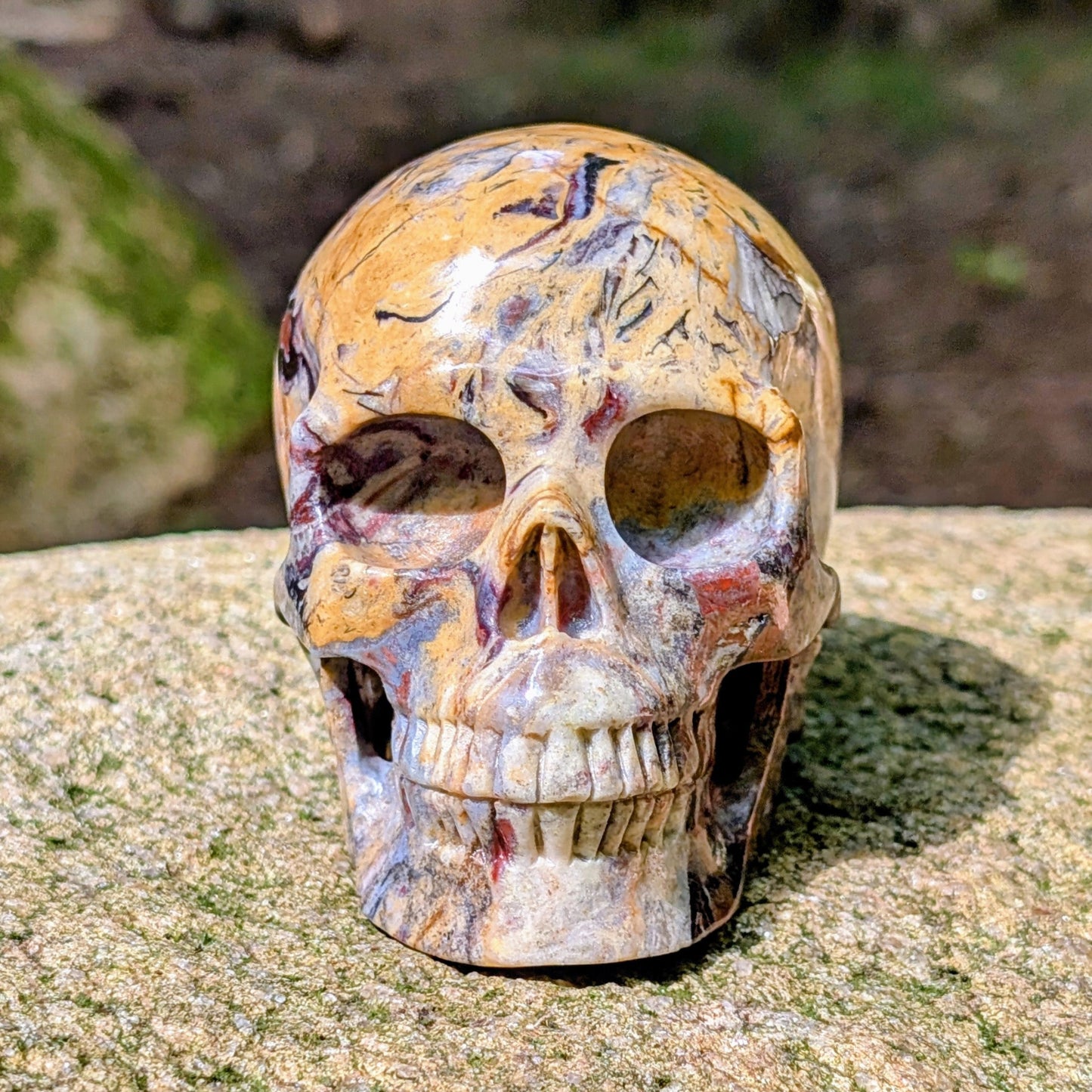 Kristallschädel "Wüstenwächter" aus Polychrom-Jaspis mit rötlicher und gelber Maserung.