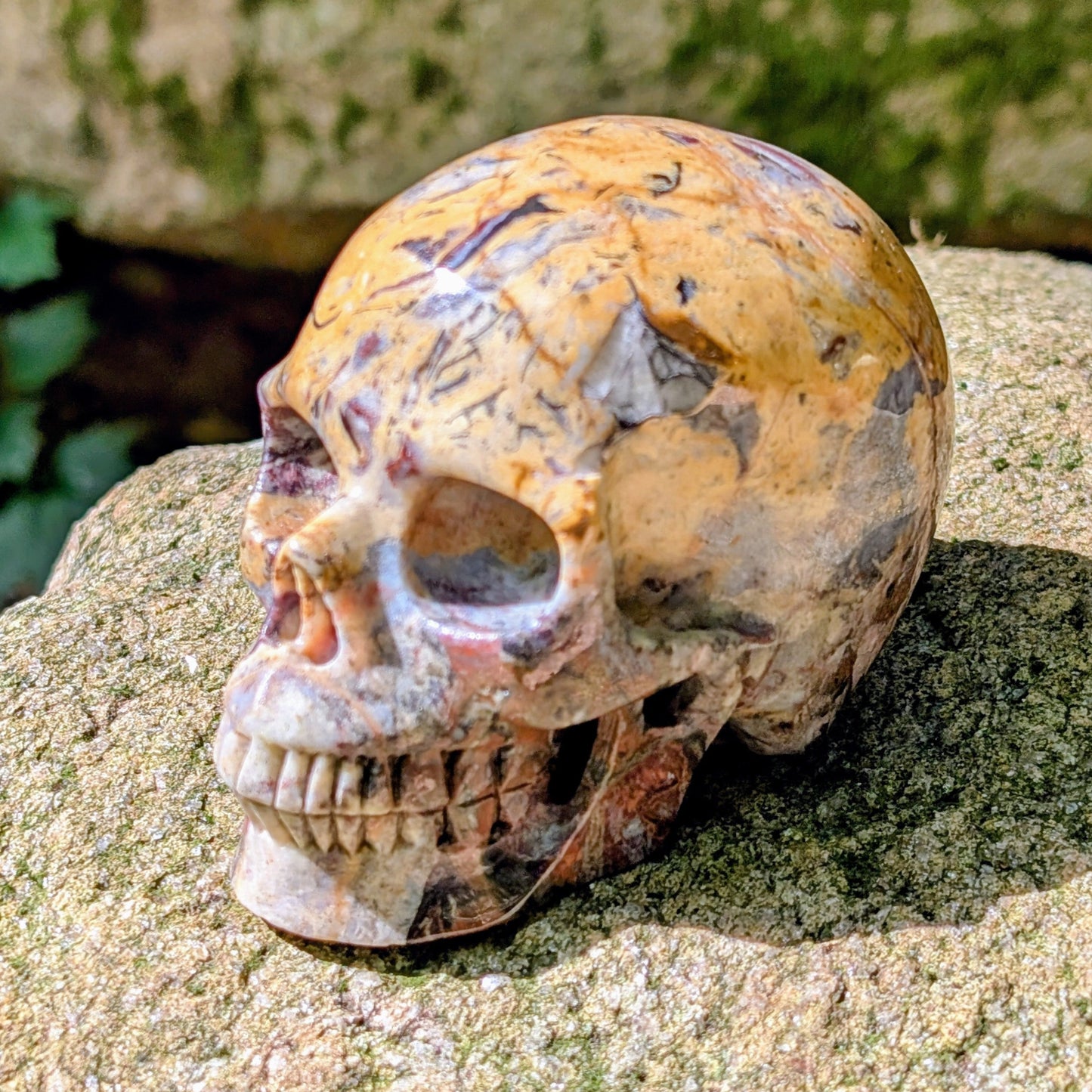 Kristallschädel "Wüstenwächter" aus Polychrom-Jaspis mit rötlicher und gelber Maserung.