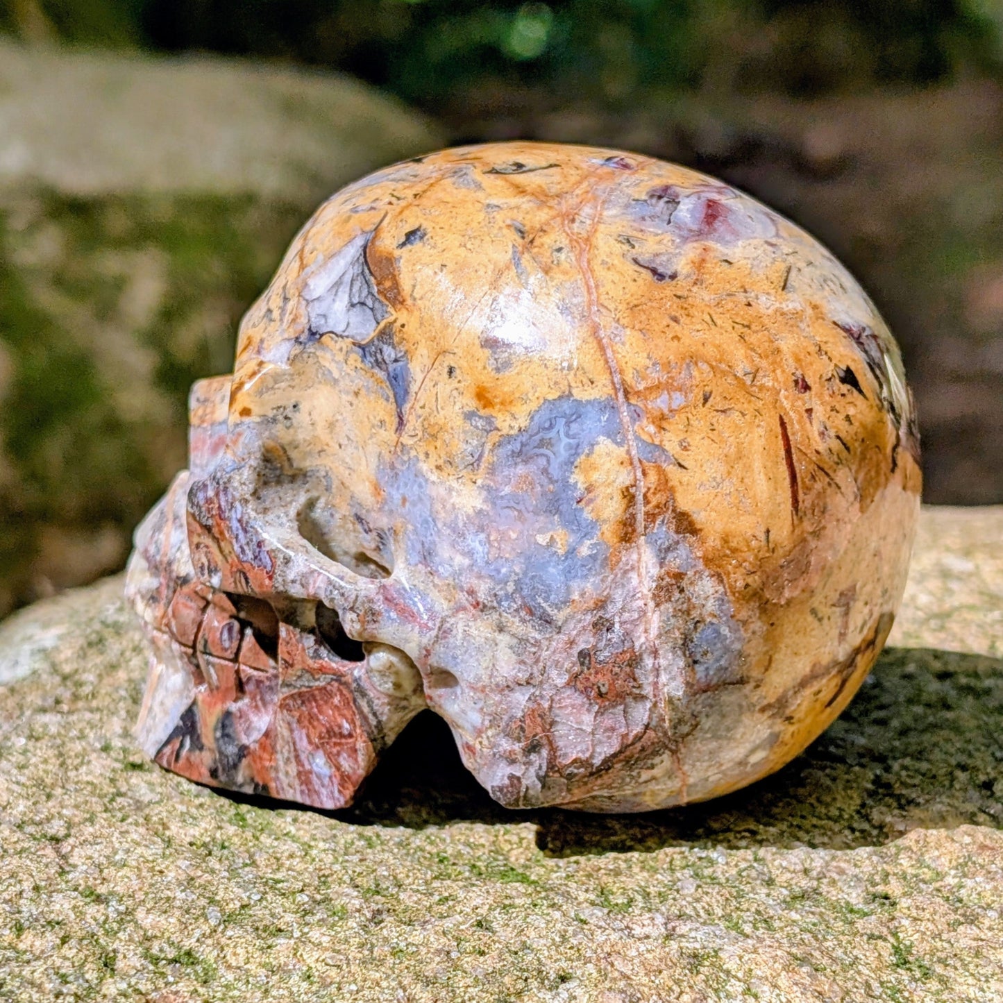 Kristallschädel "Wüstenwächter" aus Polychrom-Jaspis mit rötlicher und gelber Maserung.