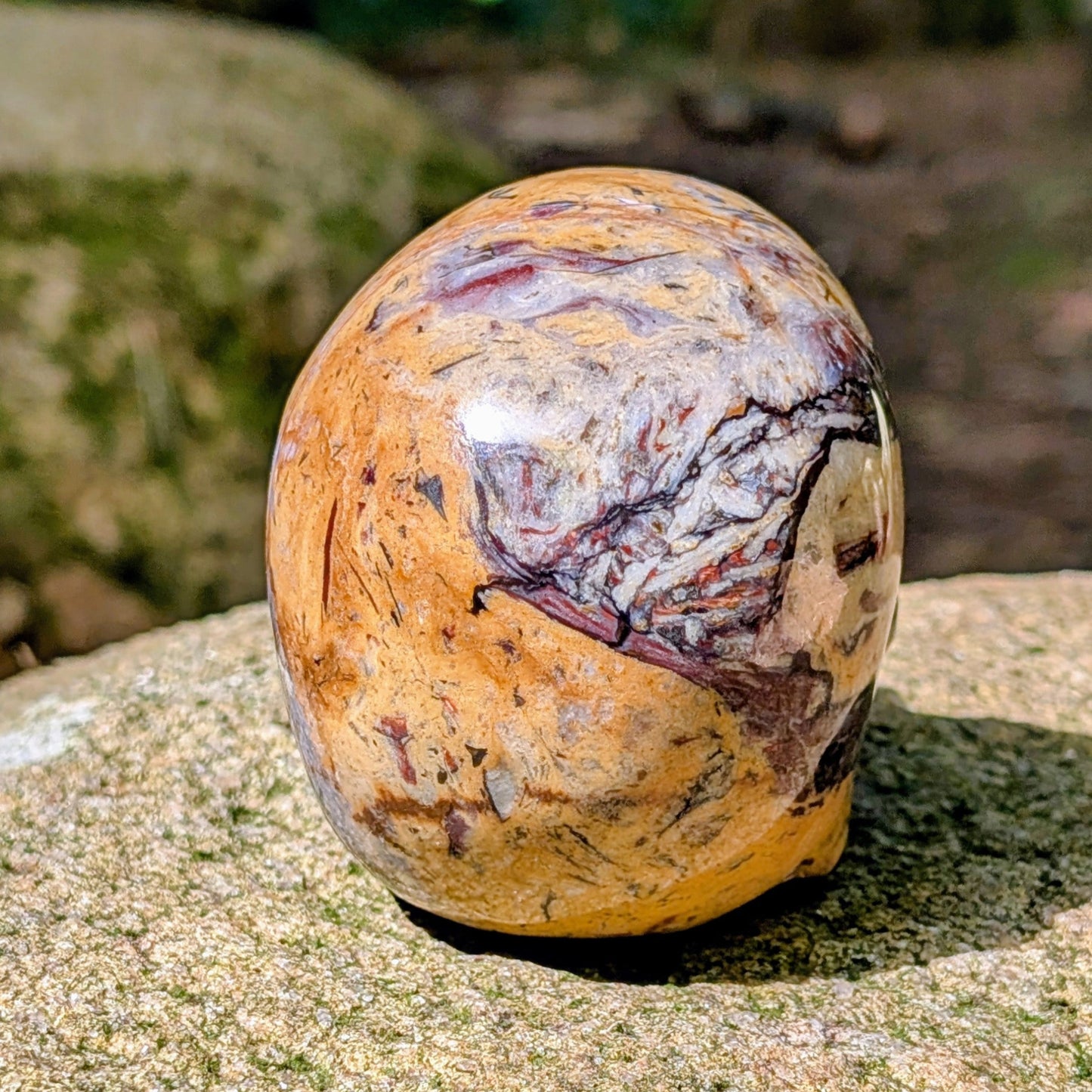 Kristallschädel "Wüstenwächter" aus Polychrom-Jaspis mit rötlicher und gelber Maserung.