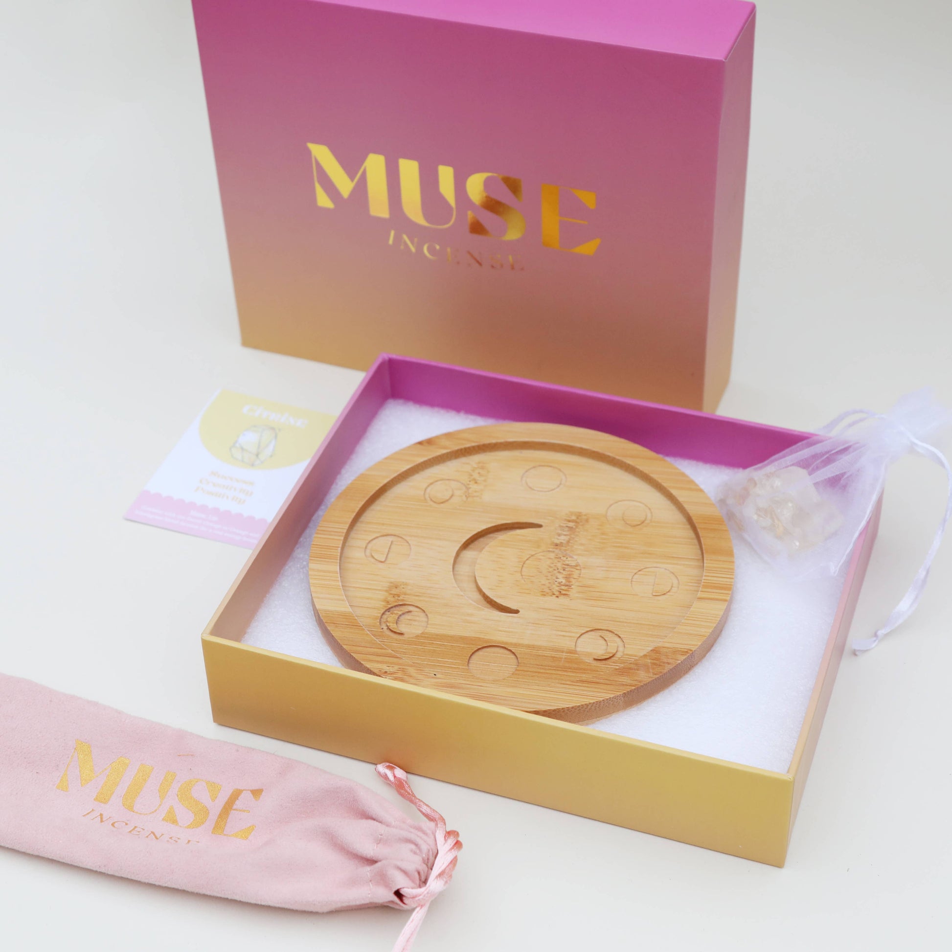 Mondphasen-Kristall-Räucherschale aus Bambus, gefüllt mit grünen Fluorit-Kristallchips, in einer rosa-orangen Geschenkbox von The Golden Altar.