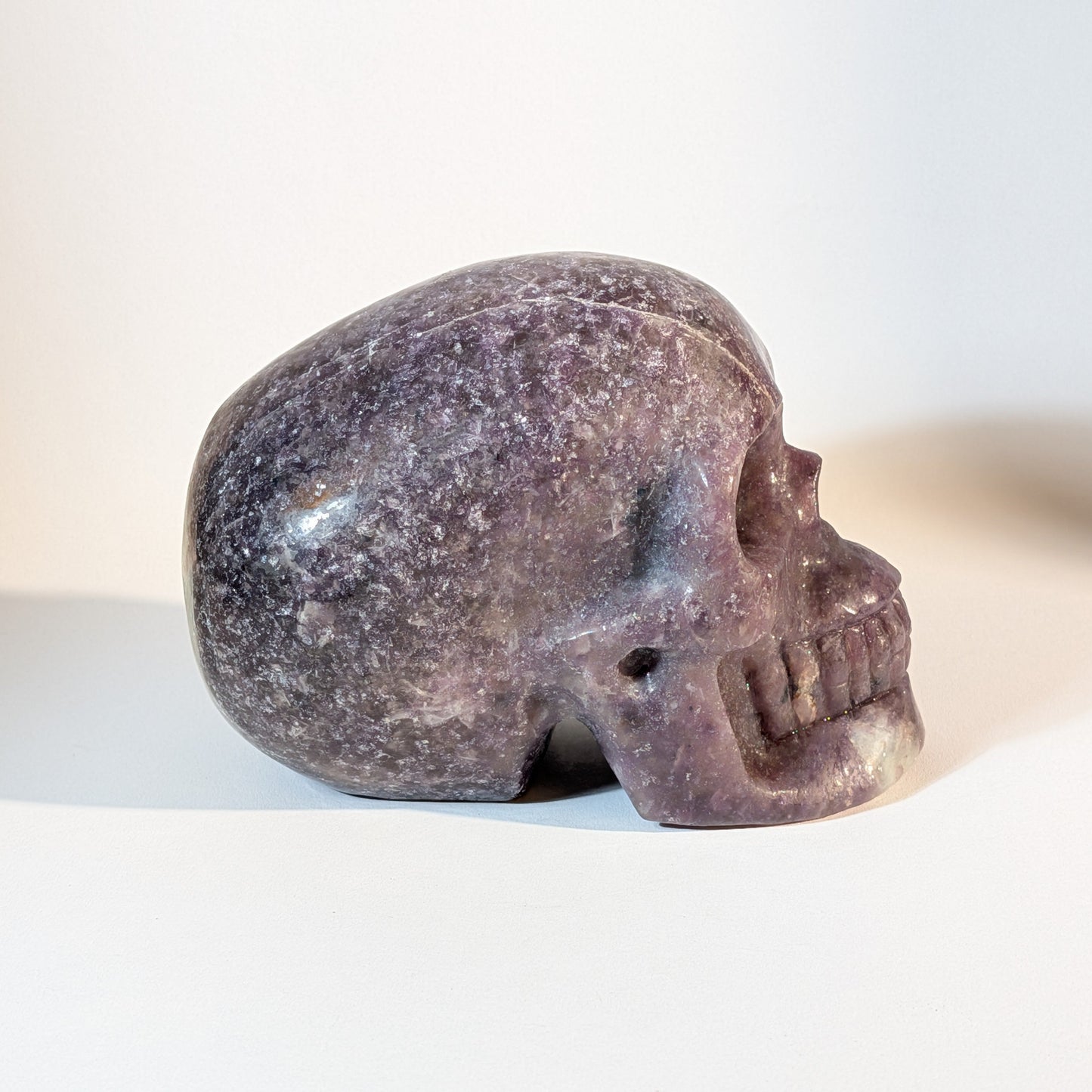 Monumentaler, handgeschnitzter Kristallschädel Corey aus violettem Lepidolith (Mischkristall-Matrix), 1810 Gramm schwer, mit weißen Einschlüssen für Stressabbau.