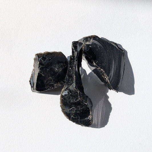 Rohsteine aus schwarzem Obsidian, die als Schutzstein dienen.