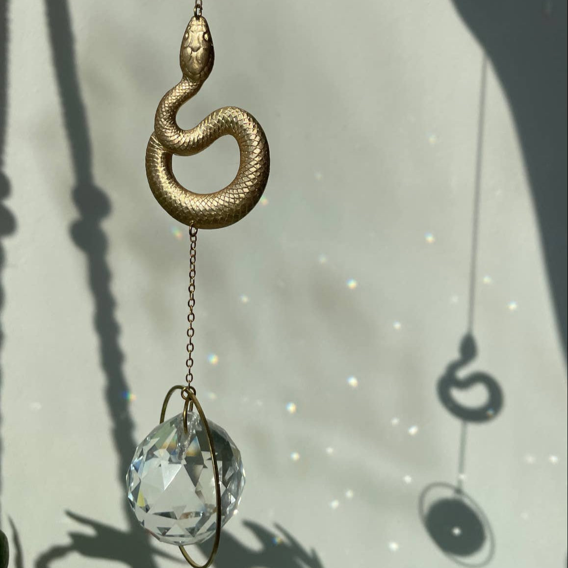 Suncatcher Schlange mit geschliffenem Kristall und Regenbogeneffekten.