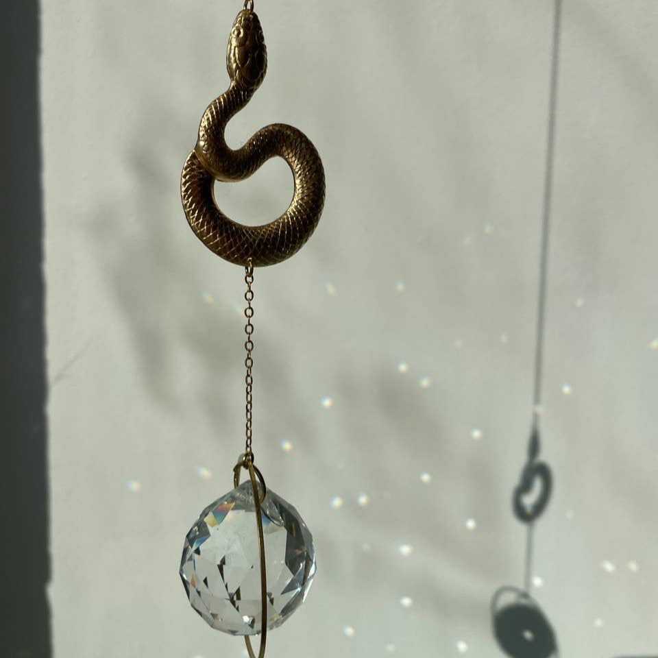 Suncatcher Schlange mit geschliffenem Kristall und Regenbogeneffekten.