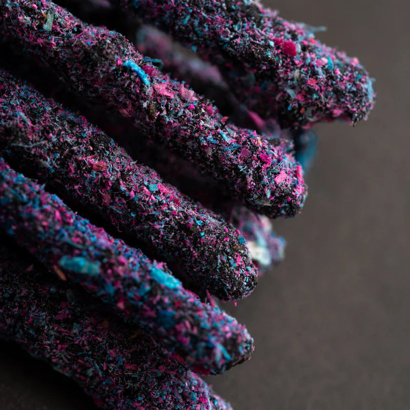 Verpackung der Sagrada Madre Cosmos Räucherstäbchen Jupiter vor einem kosmischen, lila-farbenen Hintergrund mit Planeten.