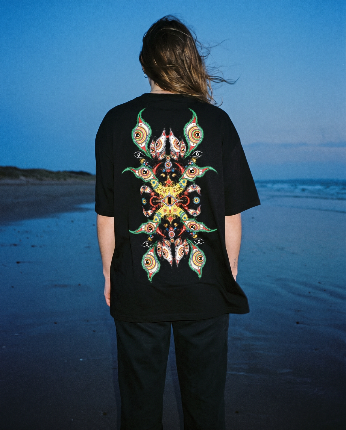 Pfau — Federn: schwarzes Oversized-T-Shirt mit Rückenprint, getragen.