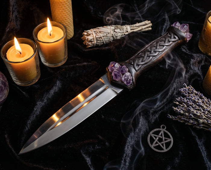 Athame Ritualklinge auf schwarzem Samt mit Amethyst-Kristallen und Kerzen – spirituelle Bedeutung und Verwendung