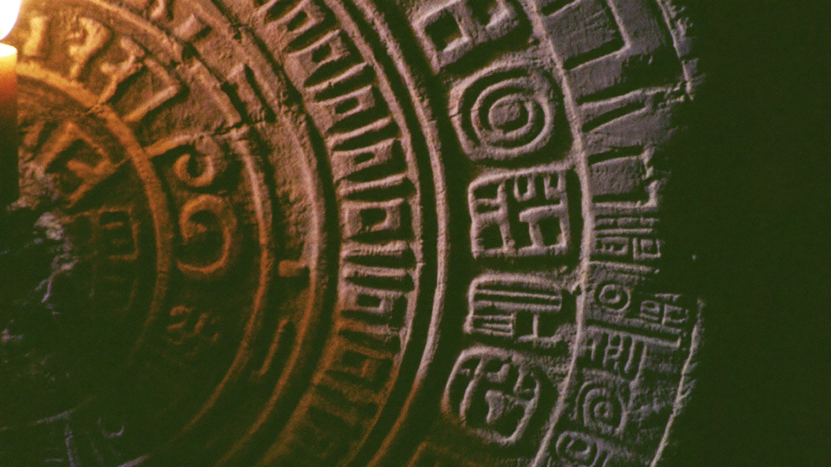 Nahaufnahme eingemeißelter Maya-Kalenderzeichen im Kerzenlicht – Portaltage August 2027