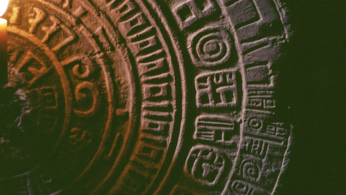 Nahaufnahme eingemeißelter Maya-Kalenderzeichen im Kerzenlicht – Portaltage August 2027