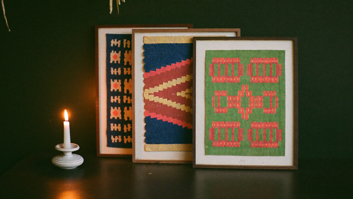 Drei gerahmte Kilim-Kunstdrucke in Azurblau, Korallrot und Grün im warmen Kerzenlicht