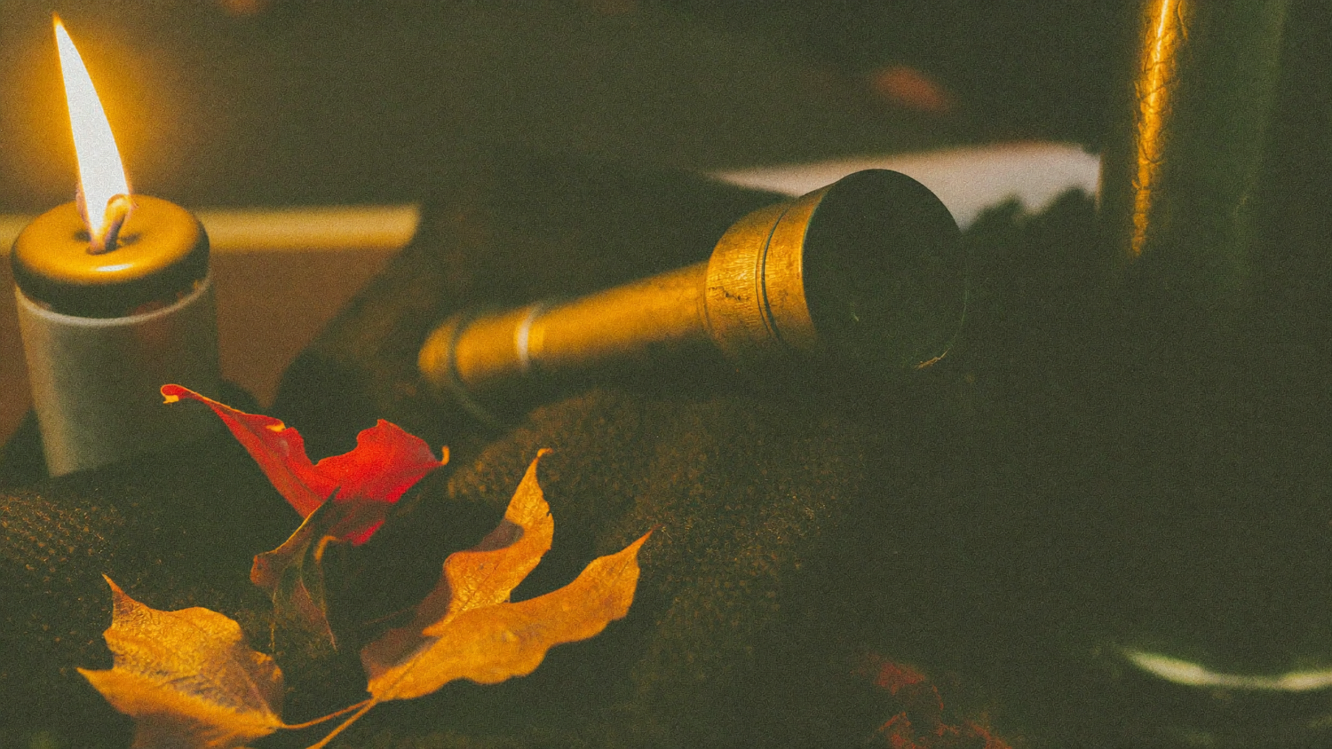 Nahaufnahme eines Messing-Fernrohrs auf einer Wolldecke mit Herbstlaub im Kerzenlicht – Orioniden 2026