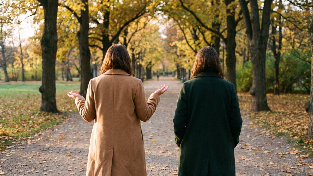 Zwei Frauen gehen im Herbst von hinten gesehen durch einen Park und sprechen miteinander – traumasensible Beratung in München
