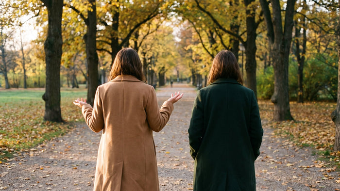Zwei Frauen gehen im Herbst von hinten gesehen durch einen Park und sprechen miteinander – traumasensible Beratung in München