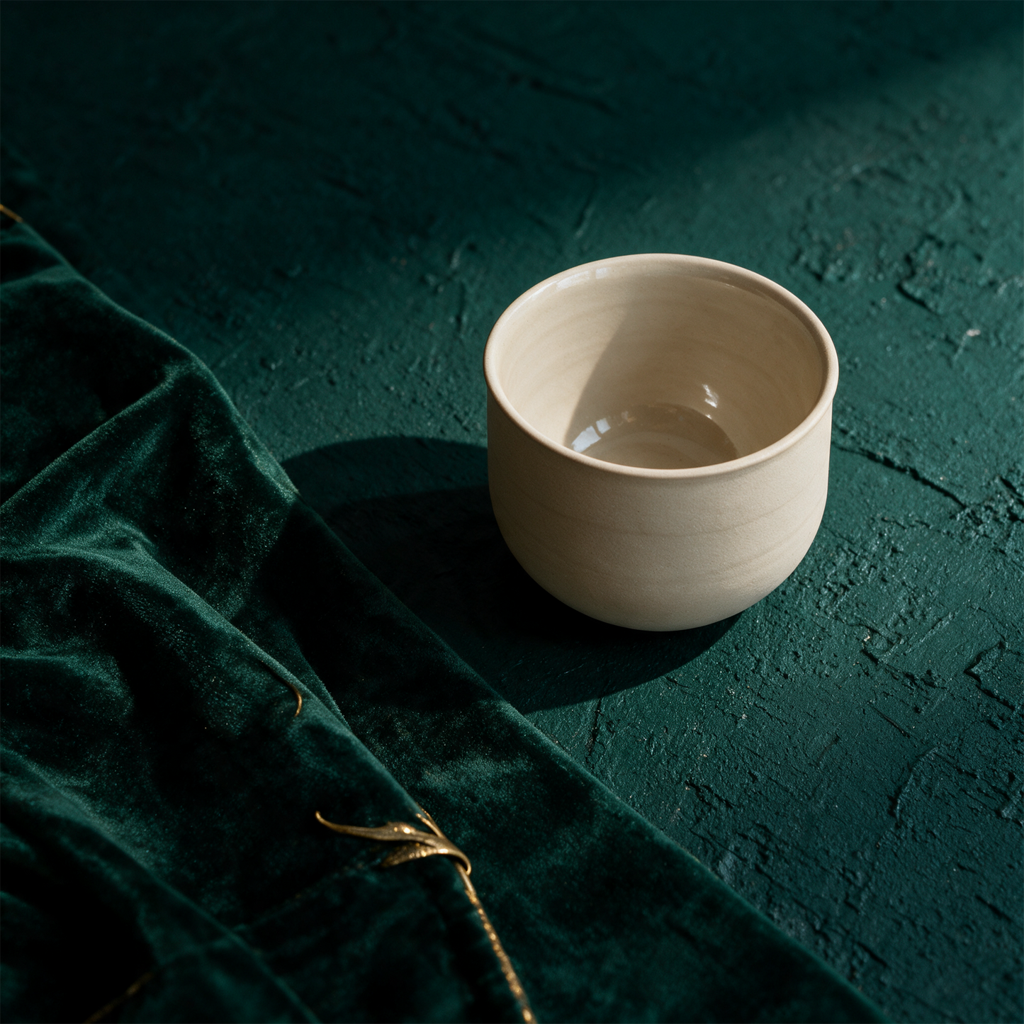 OCHA Teetasse beige – alternative Produktansicht vor tiefem Smaragdgrün