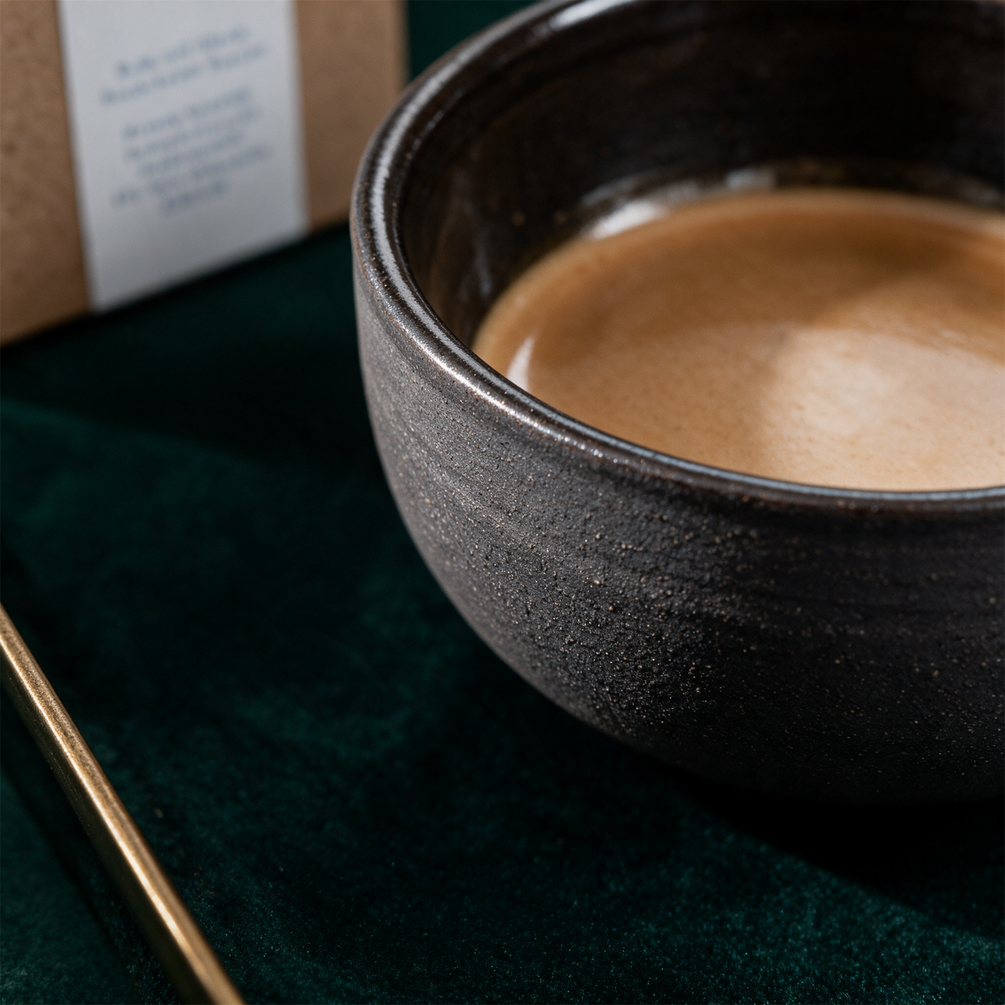 KUMO Cappuccino Tasse grau-schwarz – Detailansicht vor tiefem Smaragdgrün