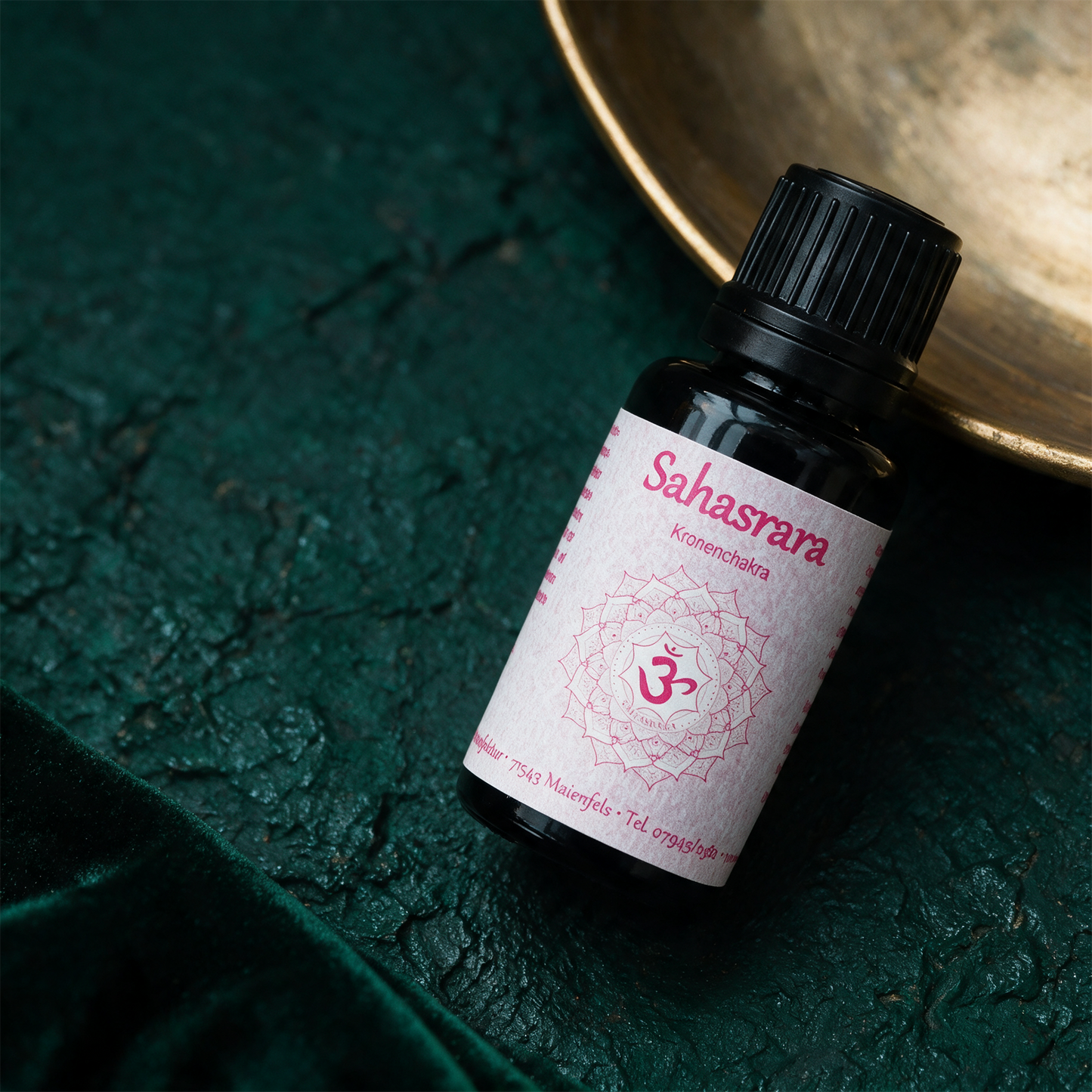 Sahasrara Chakraöl von der Seite vor tiefgrünem Hintergrund