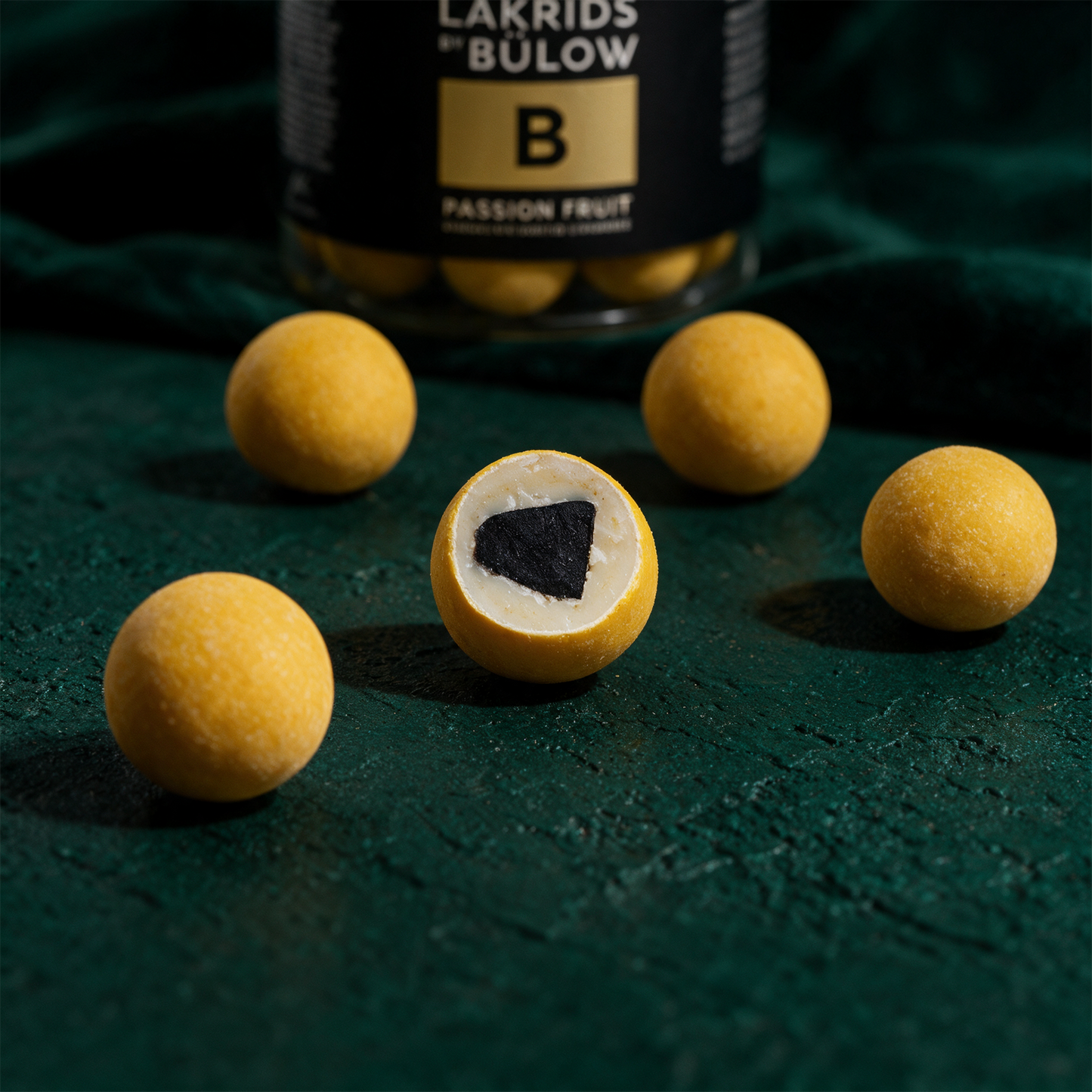 LAKRIDS by BÃ¼low Passion Fruit | Lakritz in weiÃŸer Schokolade â€“ Detailansicht vor tiefem SmaragdgrÃ¼n