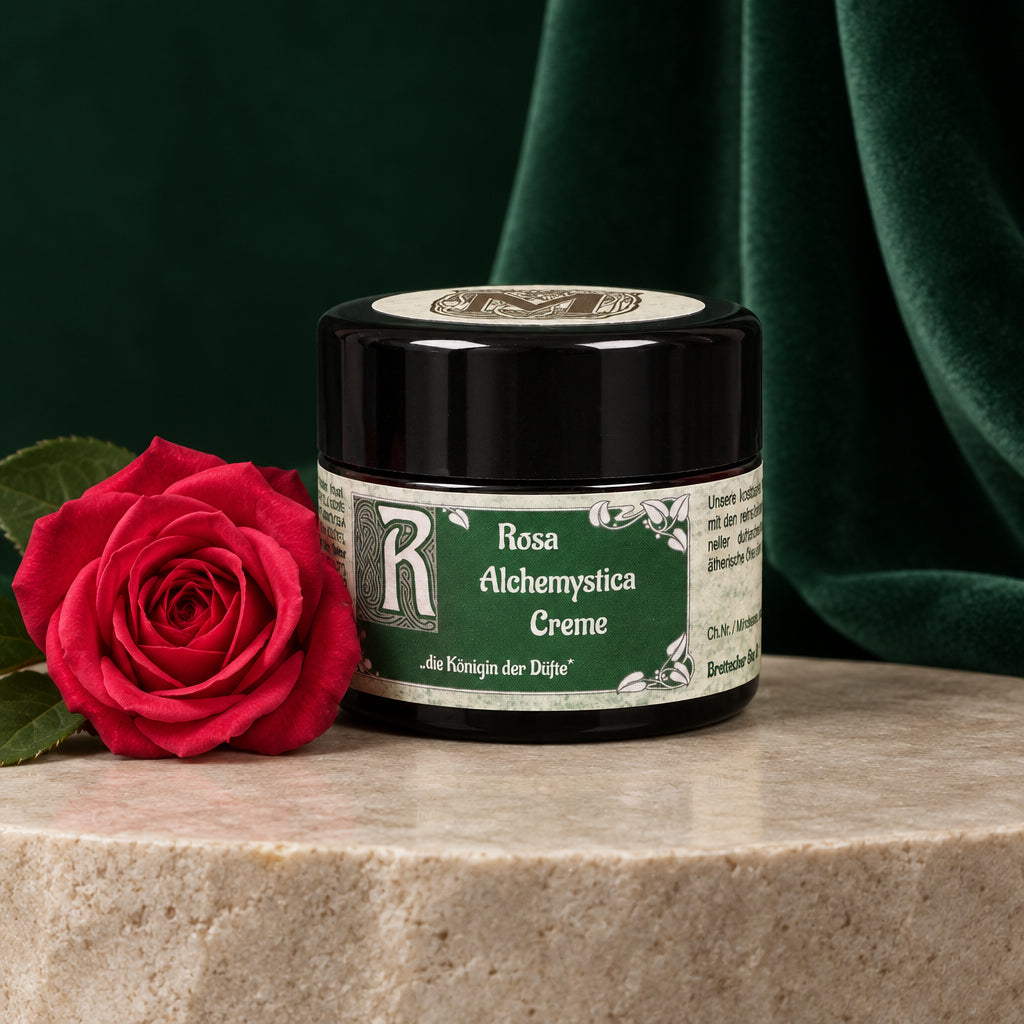 Geschlossener 35-ml-Tiegel Rosa Alchemystica Creme mit grünem Etikett vor roten Rosen