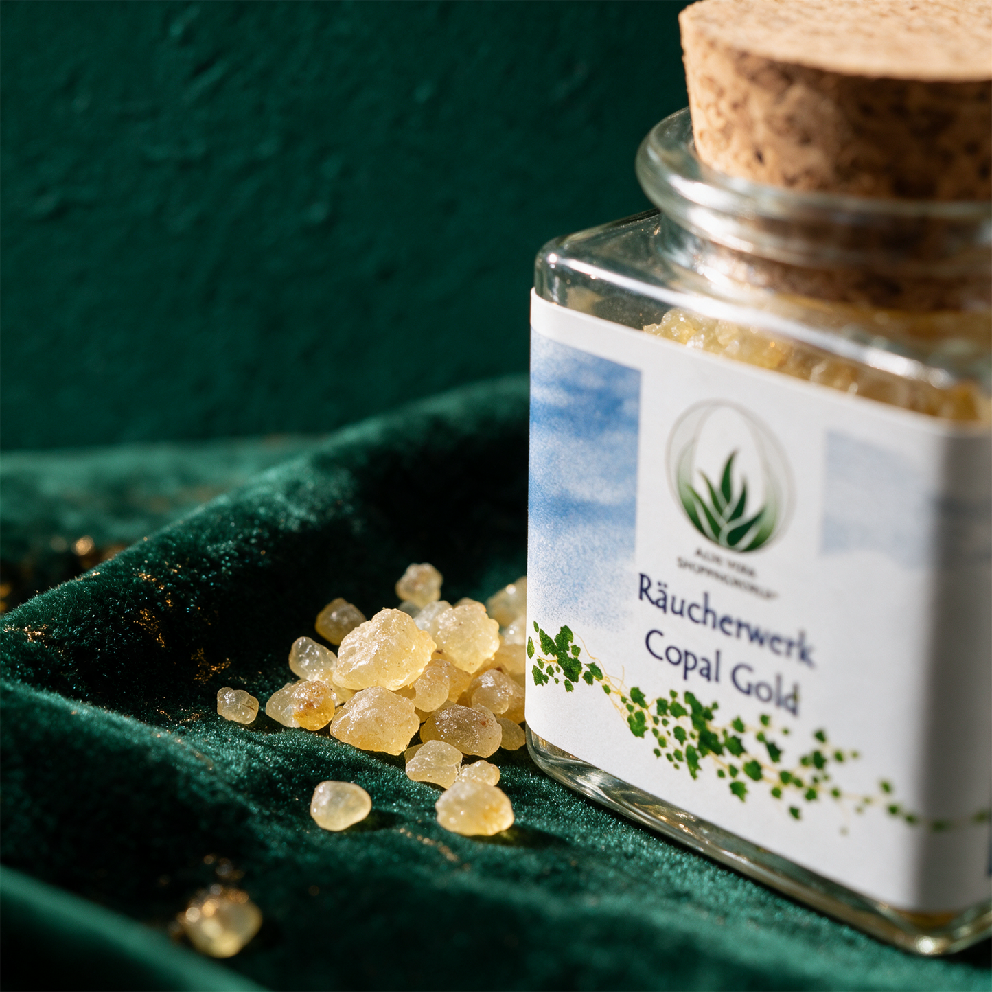 Räucherwerk "Copal Gold" Glas 50 ml – Detailansicht vor tiefem Smaragdgrün