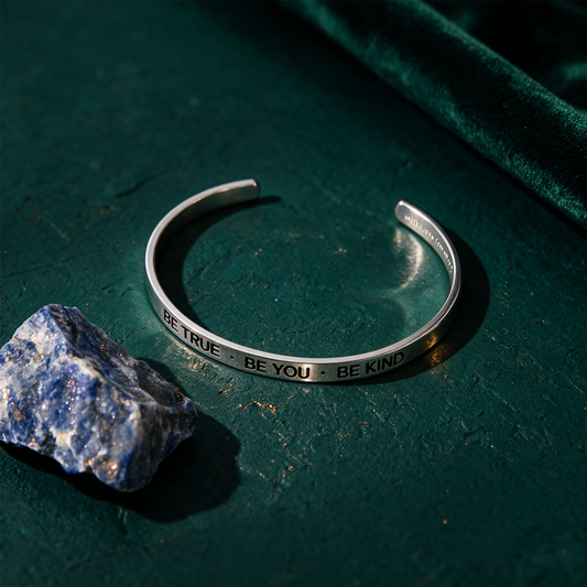 Armreif mit Gravur | Silber | "Be true - be you - be kind" – Produktansicht vor tiefem Smaragdgrün