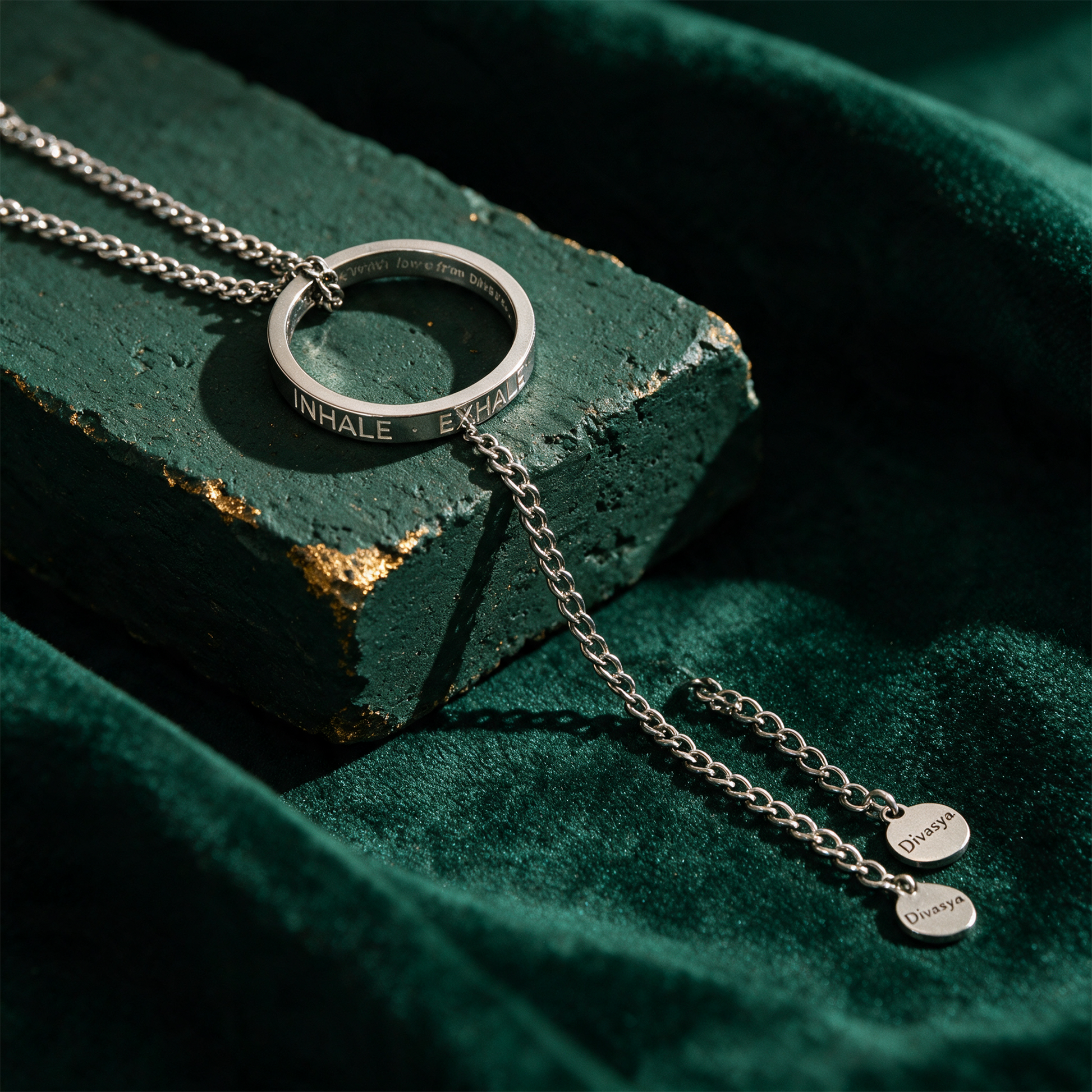 Kette mit Ring | silber | Inhale - Exhale – Material- und Setansicht vor tiefem Smaragdgrün
