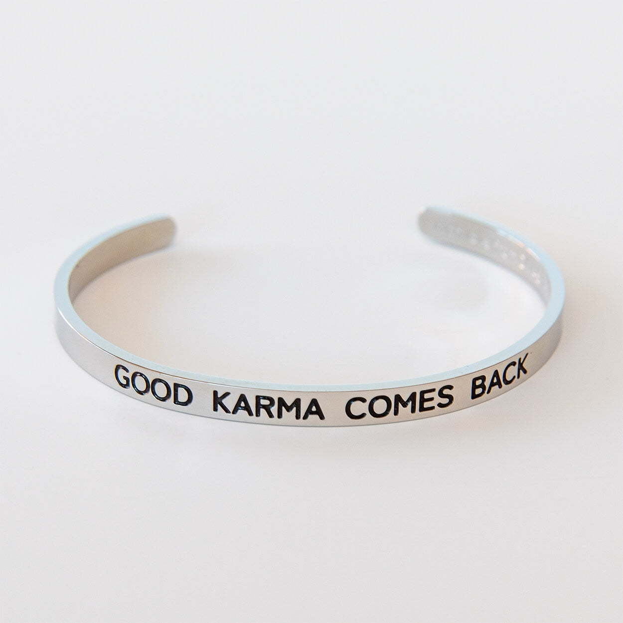 Silberfarbener Armreif aus Edelstahl mit Gravur „Good Karma comes back“
