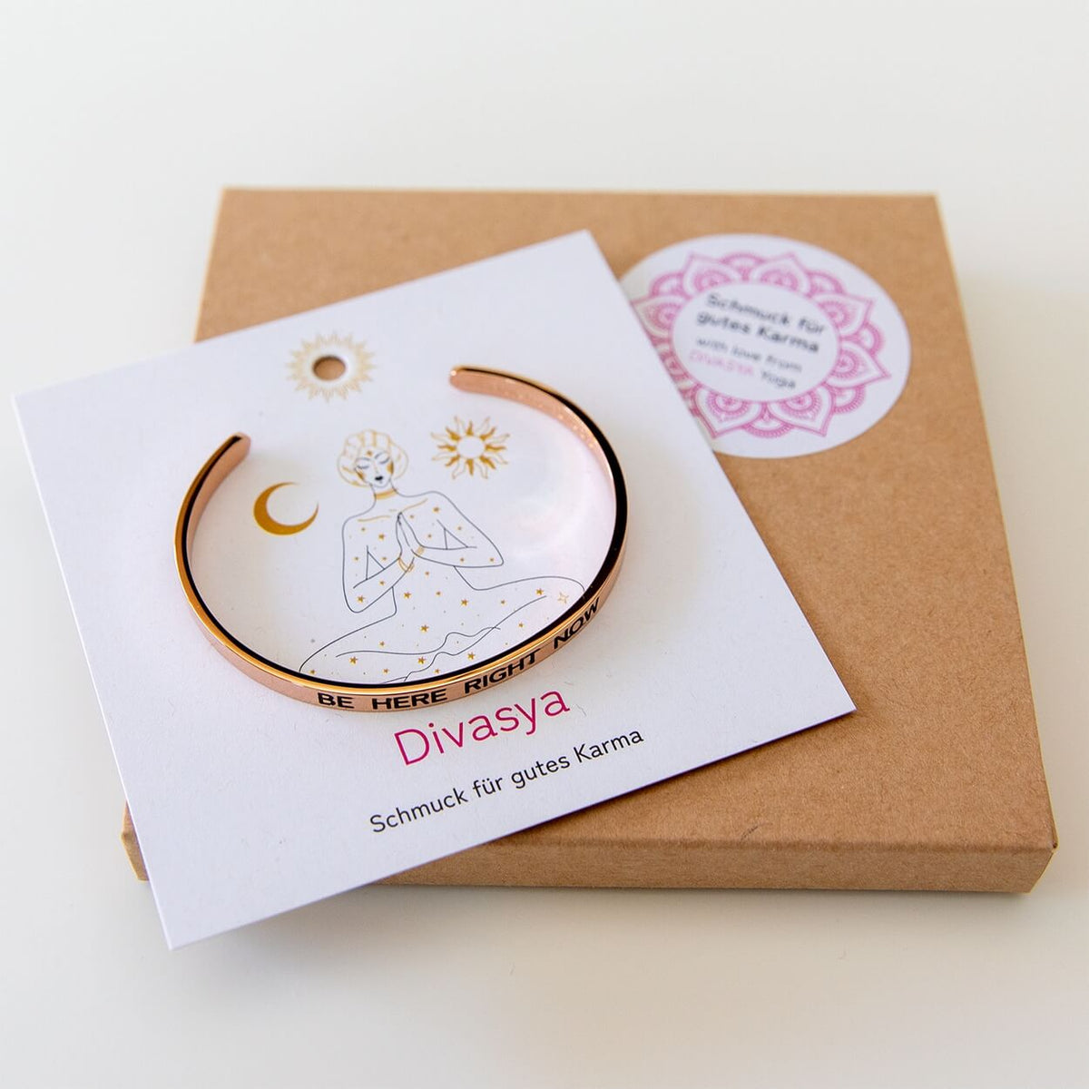 Rosévergoldeter Yoga-Armreif mit Affirmationskarte auf Packpapier