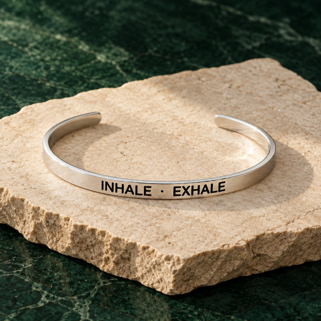 Silberner Armreif mit Gravur „Inhale, Exhale“ vor hellem Hintergrund