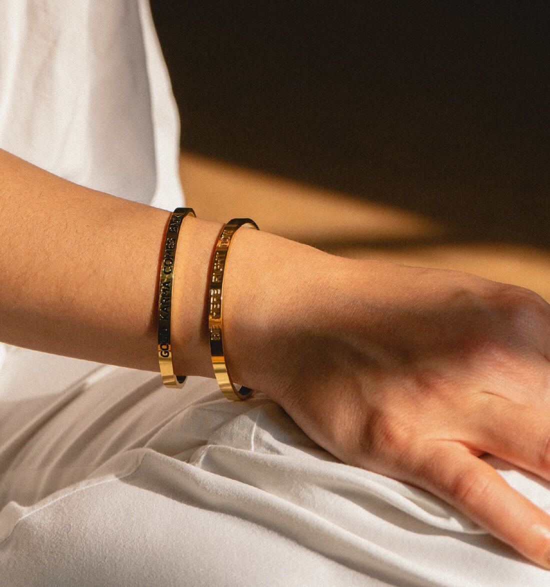 Armreif 'Be here right now' aus vergoldetem Edelstahl am Handgelenk