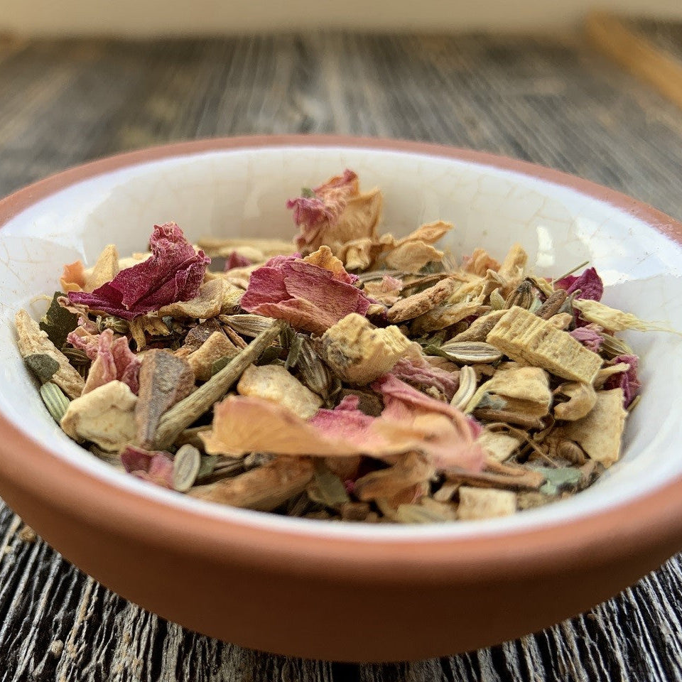 Vata Teemischung lose in einer Tonschale mit Rosenblüten
