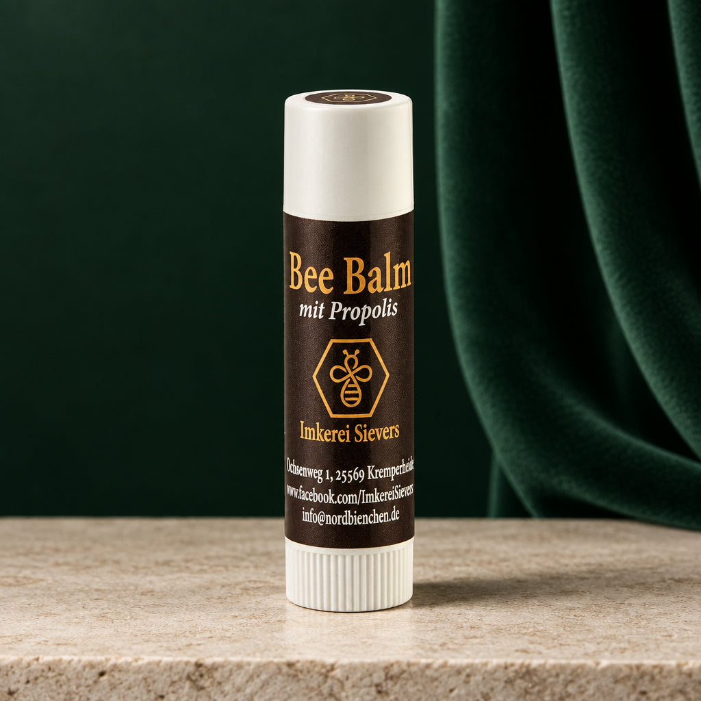 Bee Balm mit Propolis der Imkerei Sievers, dunkelbrauner Lippenpflegestift mit weißer Kappe vor orangem Hintergrund