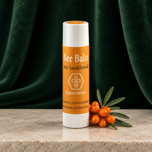 Bee Balm mit Sanddornöl der Imkerei Sievers, oranger Lippenpflegestift mit weißer Kappe vor orangem Hintergrund