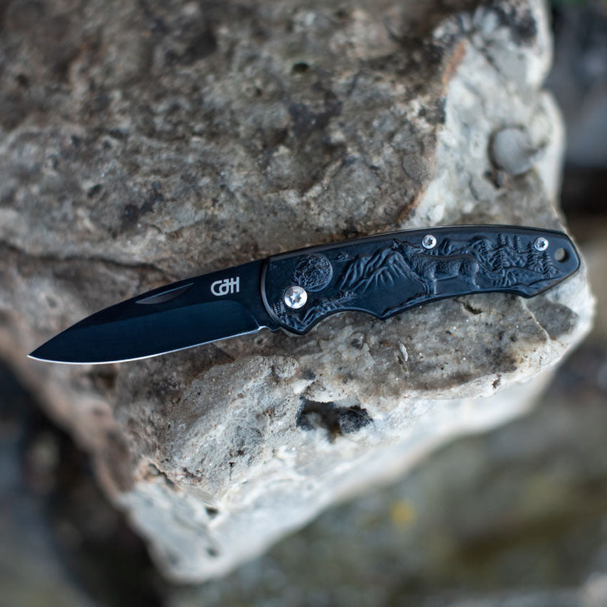 CJH Taschenmesser Wolf geöffnet auf Felsgestein
