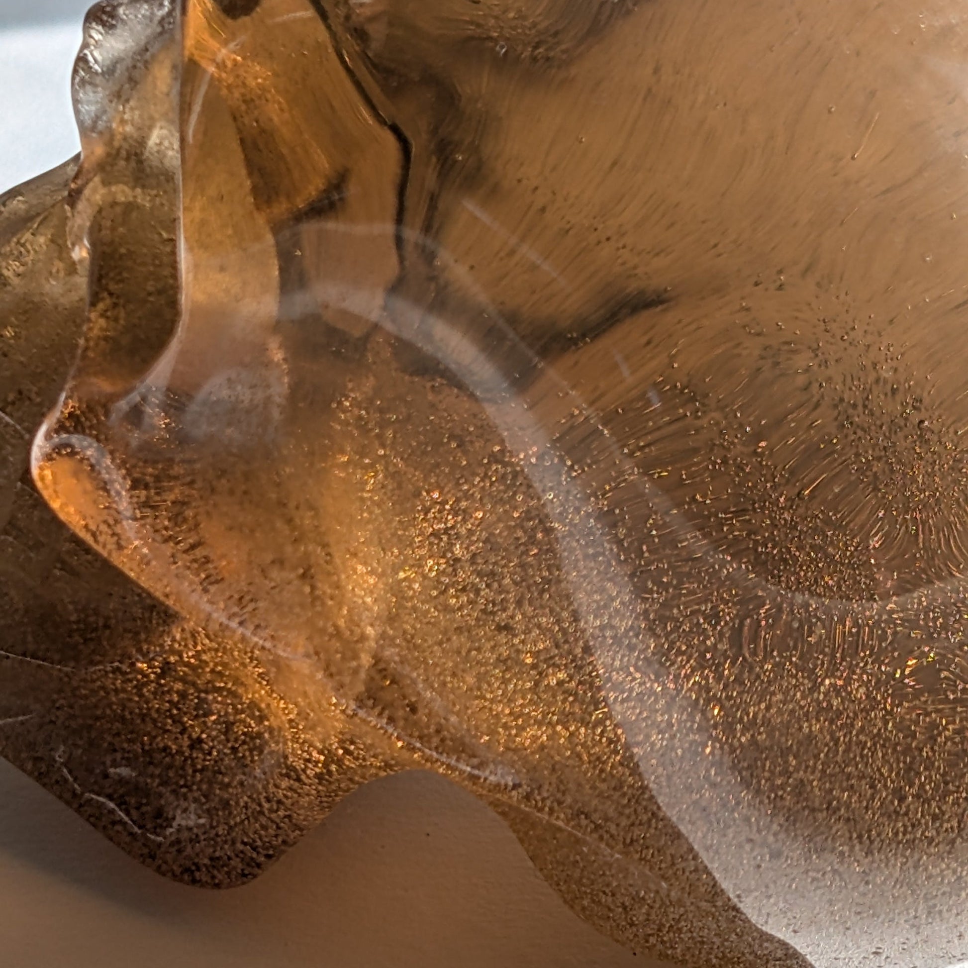 Ein 258g schwerer, synthetischer Rauchquarz-Schädel 'Auric' mit unzähligen goldenen Partikeln, die wie Sternenstaub im Licht funkeln.
